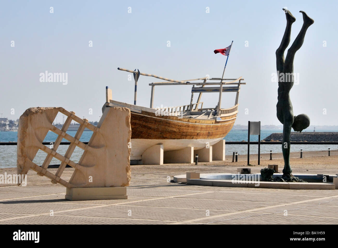 Bahrain National Museum, mostre storiche all'aperto sul mare, tra cui un sammaro Barca e Perla Diver scultura Manama Golfo Persico Medio Oriente Foto Stock