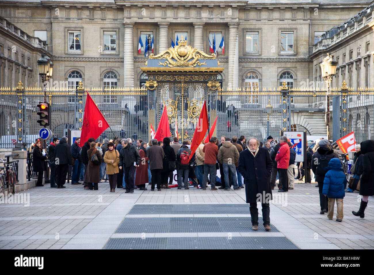 Un uomo si allontana dai dimostranti comunista al di fuori di un edificio governativo a Parigi, Francia. Foto Stock
