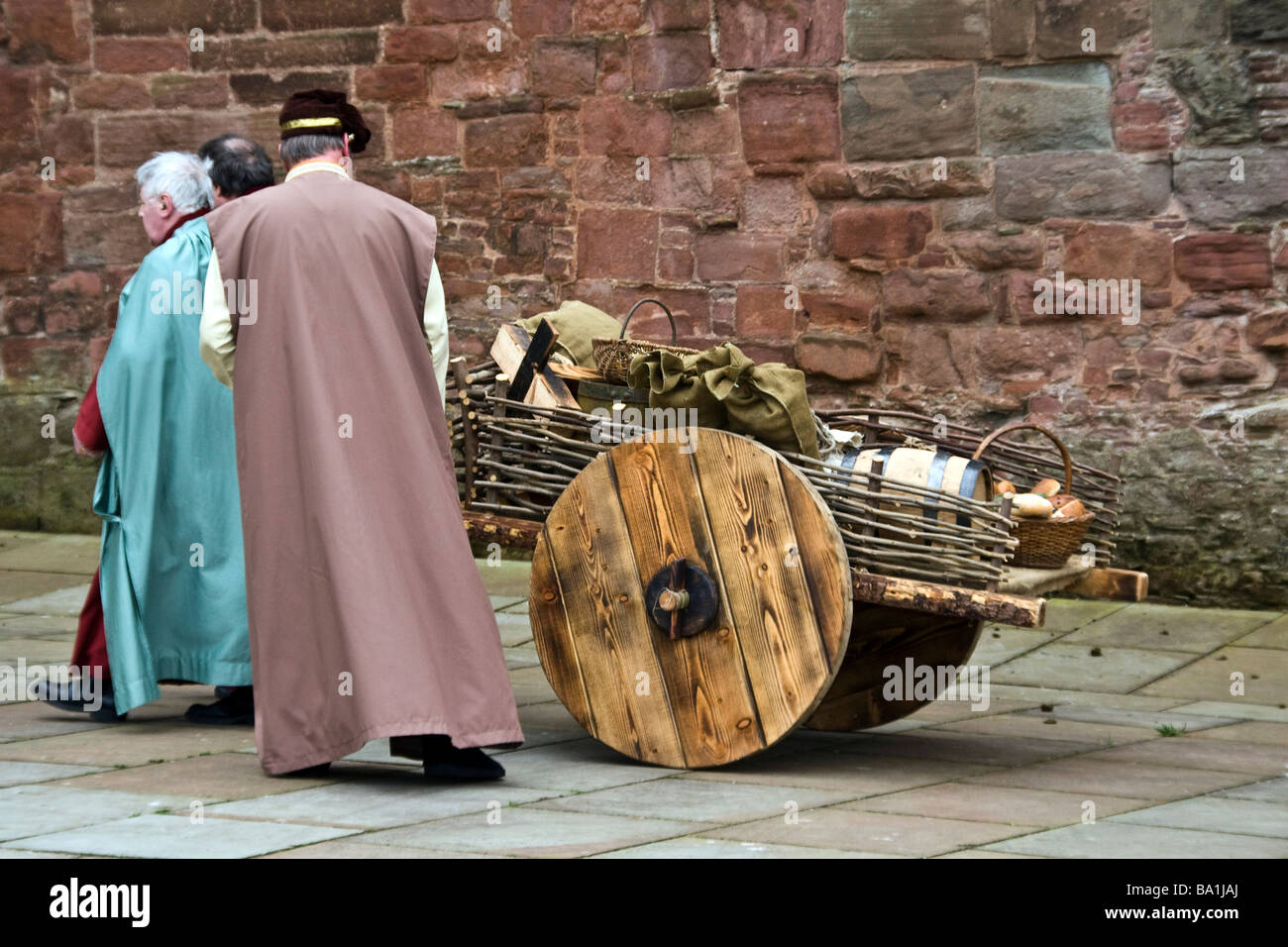 I contadini di portare un carrello pieno di cibo come un offerta durante la rievocazione di dichiarazione di indipendenza a Arbroath Abbey Foto Stock