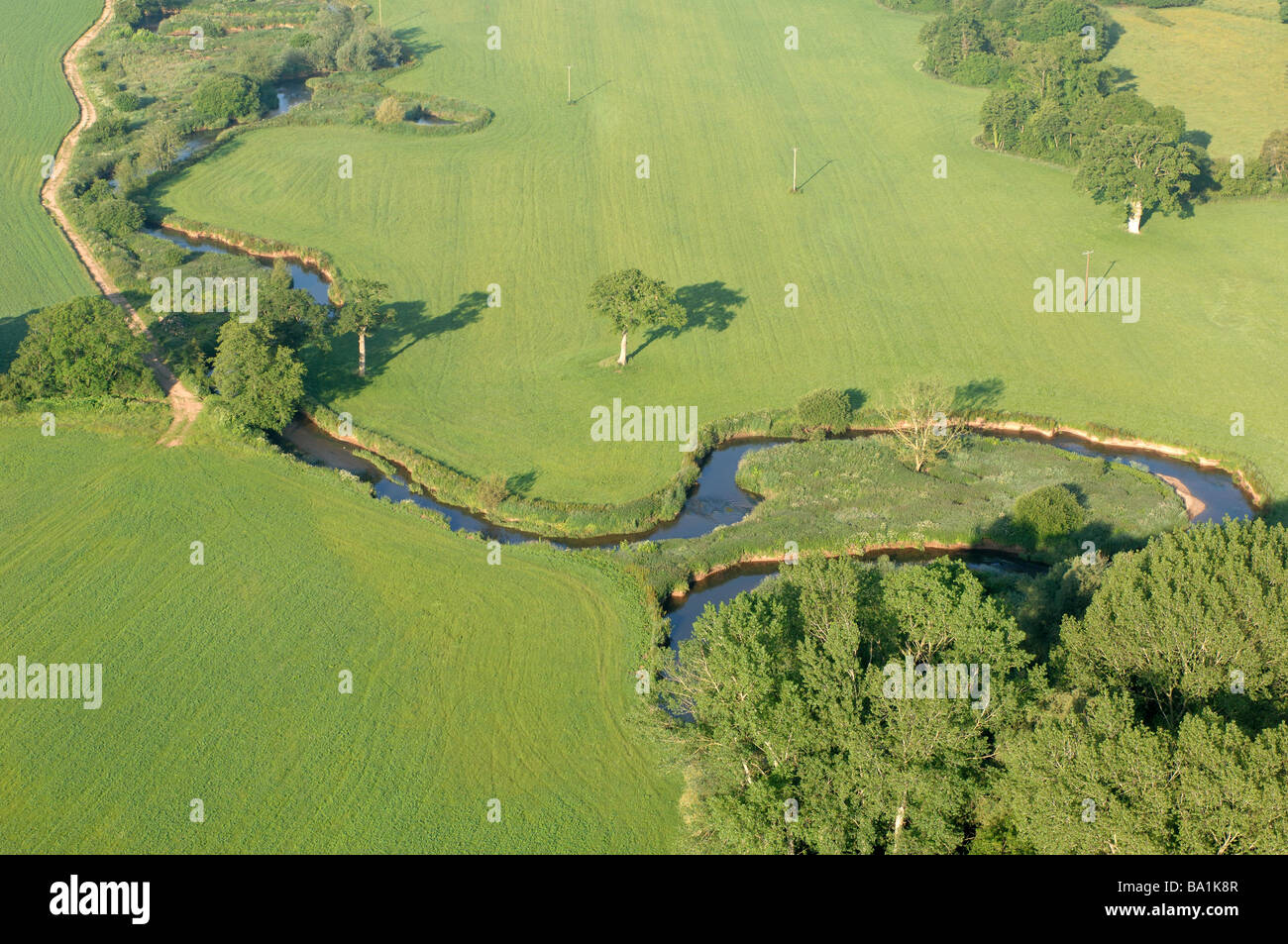 Vista aerea di meandri in un piccolo fiume circondato da campi a metà Devon England Foto Stock