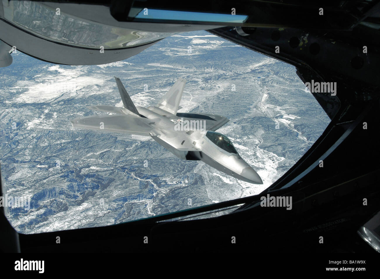 Un F-22 Raptor banche lontano da una KC-135 Statotanker durante una operazione di rifornimento. Foto Stock