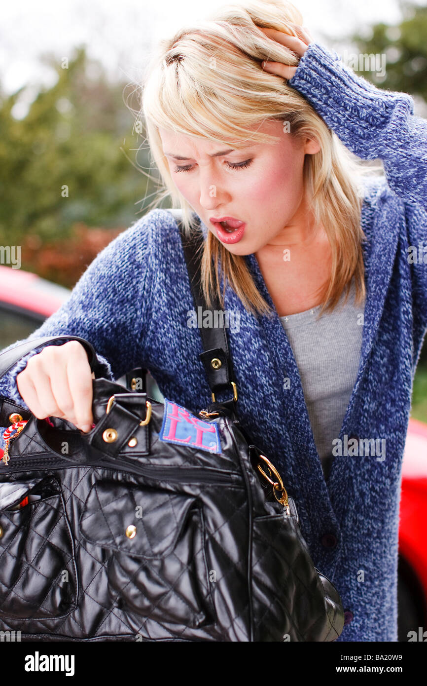 La ricerca della donna nella sua borsa per la sua borsa o telefono cellulare Foto Stock