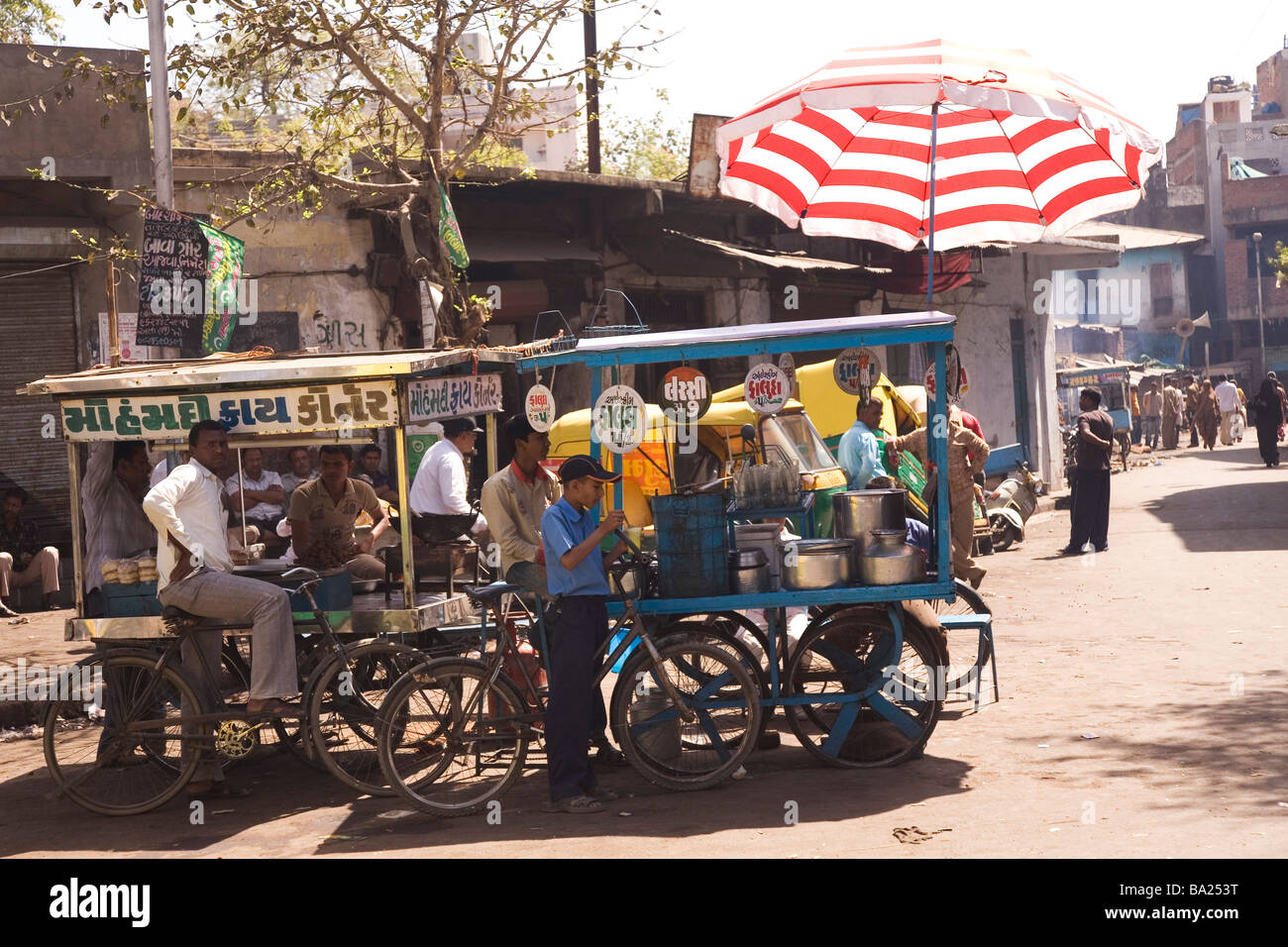 Il cibo è venduto al mobile si spegne nella vecchia città di Ahmedabad, Gujarat. Un ombrello fornisce ombra dalla feroce sun. Foto Stock