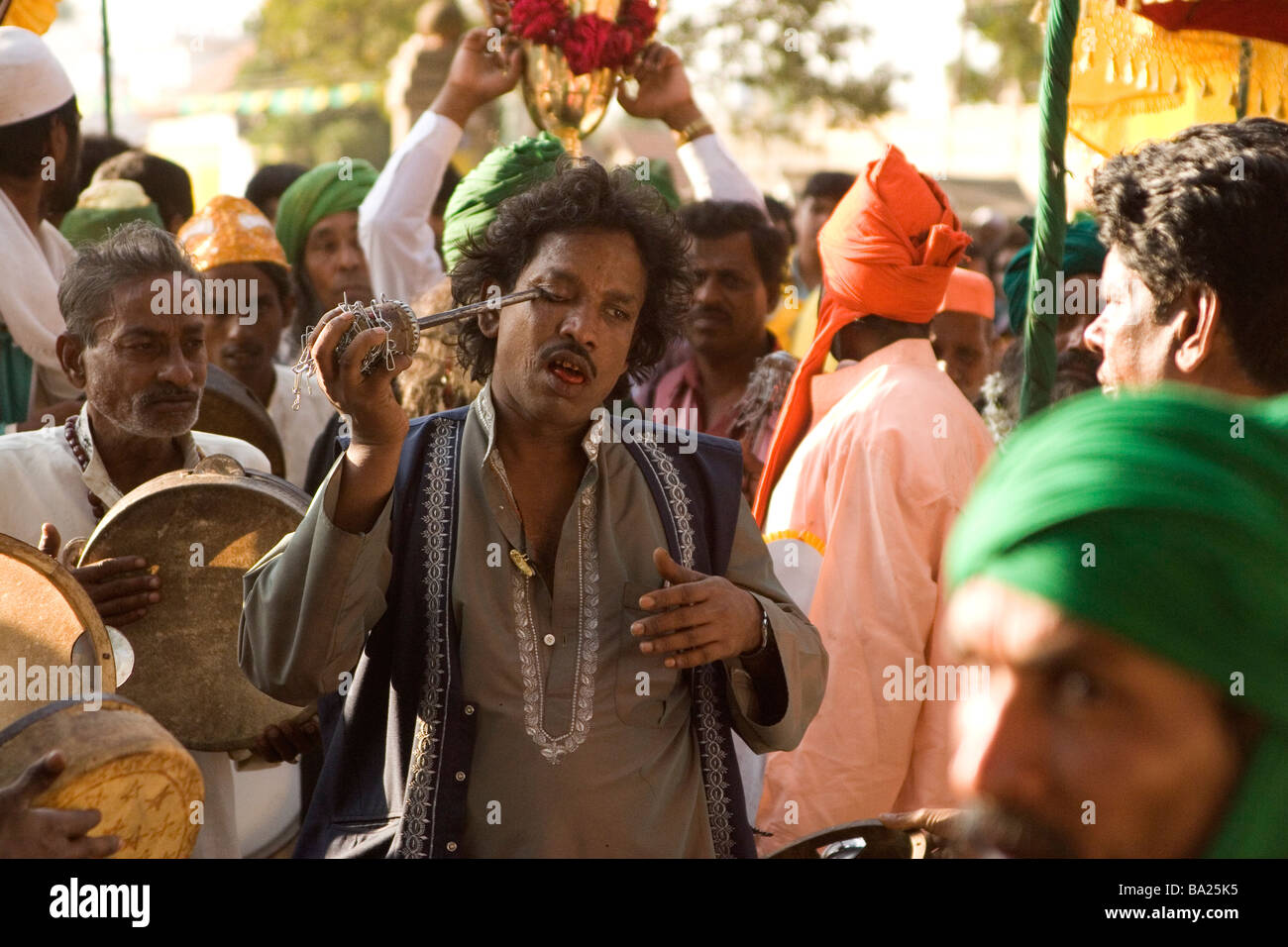 Un Fakir impala lui stesso nell'occhio con una barra di ferro nel corso di una cerimonia in onore della memoria del Sultano Tipu di Mysore, India. Foto Stock