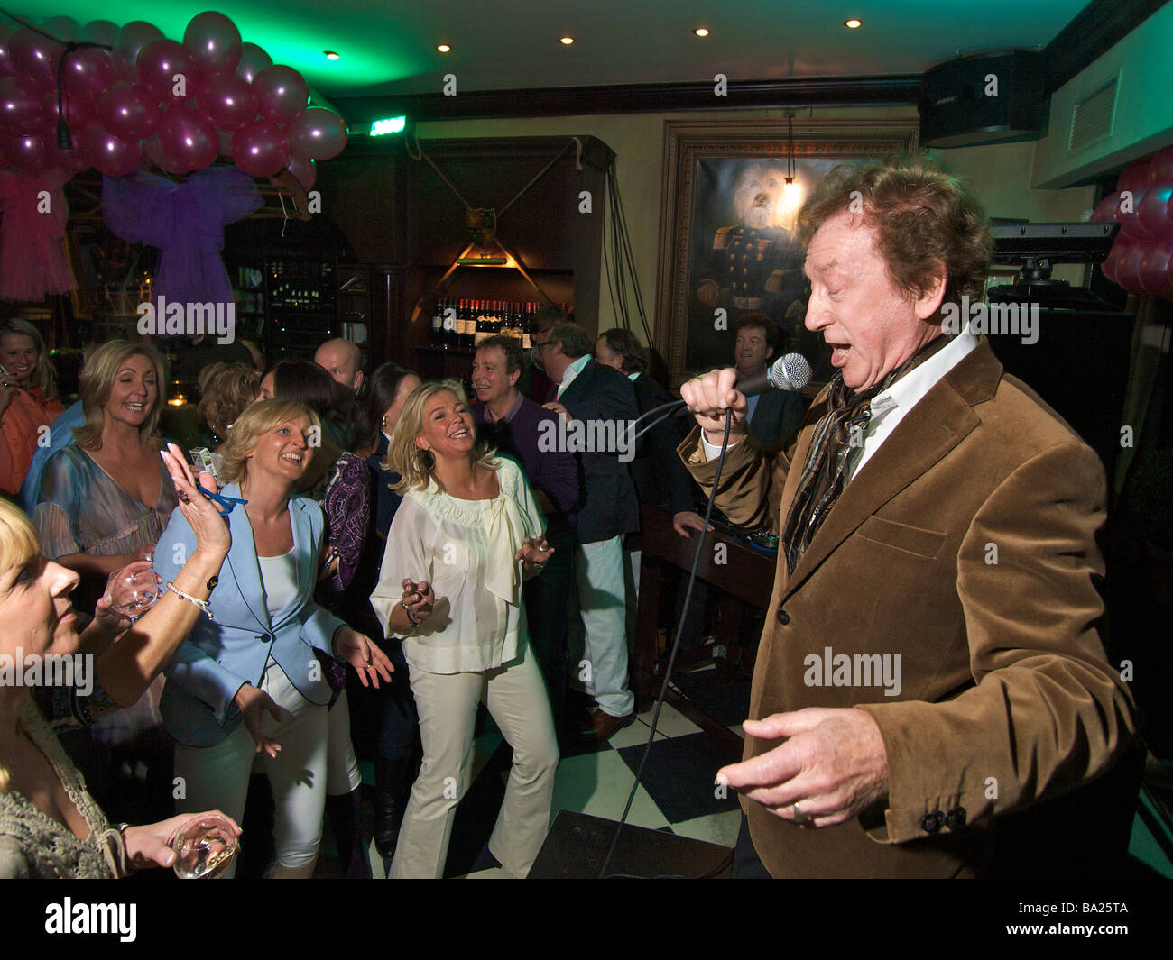 Il 78-enne crooner Harry cantare ad un party in un bar con donne che danzano e avente una buona volta Foto Stock