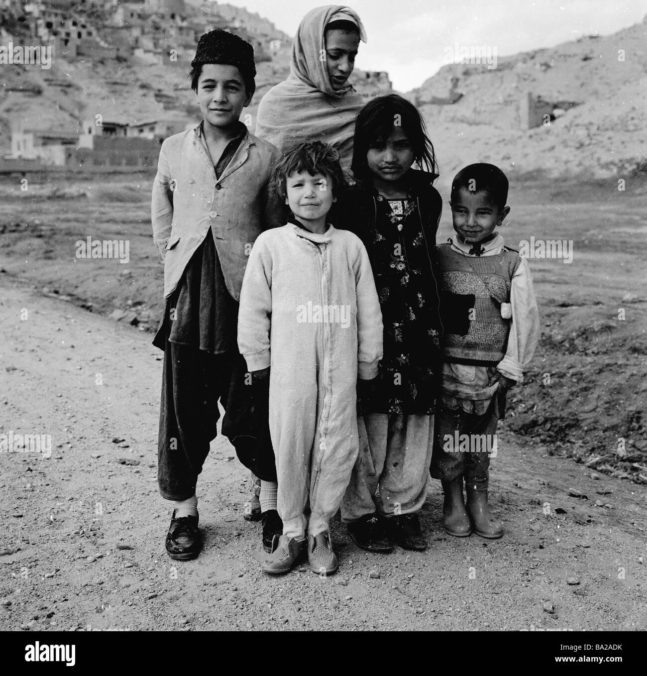 1950s, una foto di J Allan Cash di una madre con i suoi quattro figli, indossando abiti tradizionali afghani, su un sentiero collinare vicino a Kabul, Afghanistan. Foto Stock