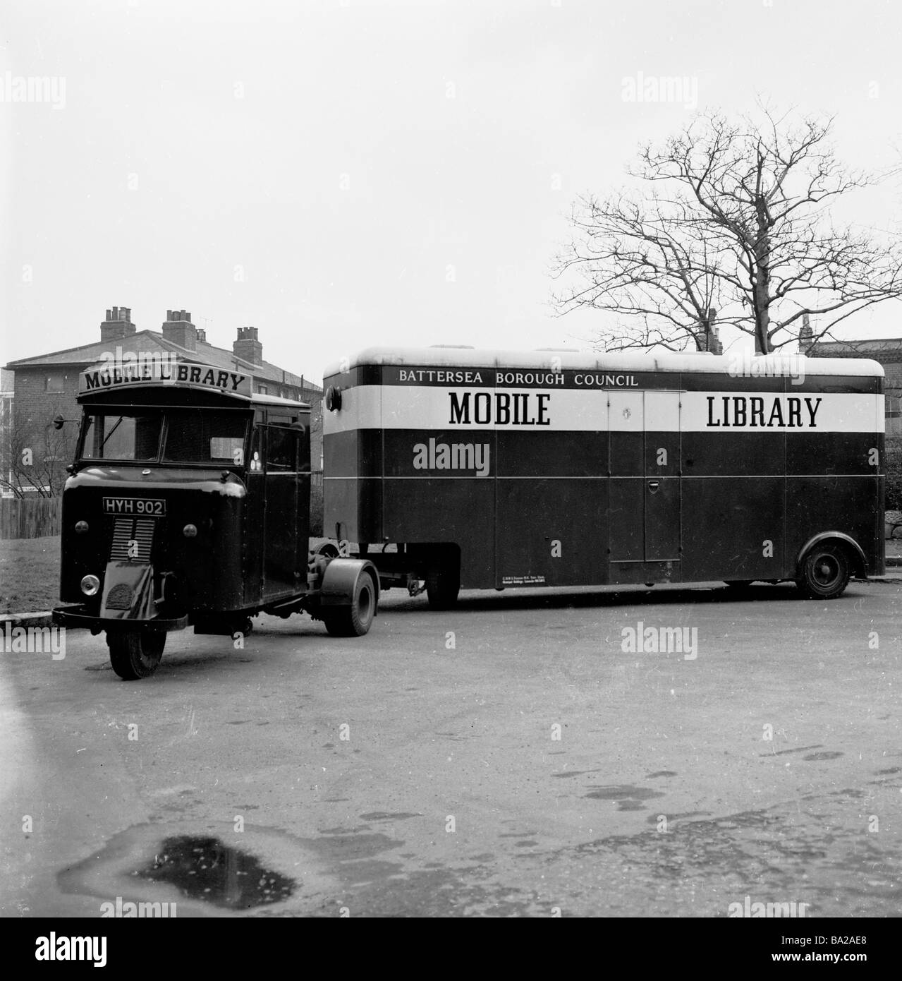 1950s, storica, una biblioteca mobile, collegata ad un veicolo a motore a tre ruote, parcheggiata all'esterno di una proprietà immobiliare, Battersea, Londra del Sud, Inghilterra, Regno Unito. Foto Stock