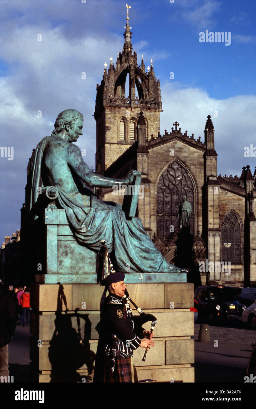 Giles alta Kirk Edimburgo con il David Hume statua e un piper in primo piano. Foto Stock