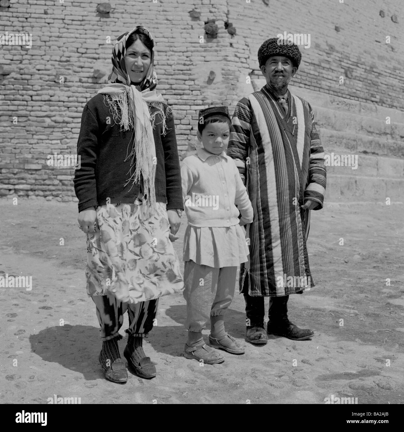 Una famiglia uzbeka posa per una foto fuori le mura dell'Arca, un'antica fortezza a Bukhara, Uzbekistan, in questa foto scattata negli anni '1950s. Foto Stock