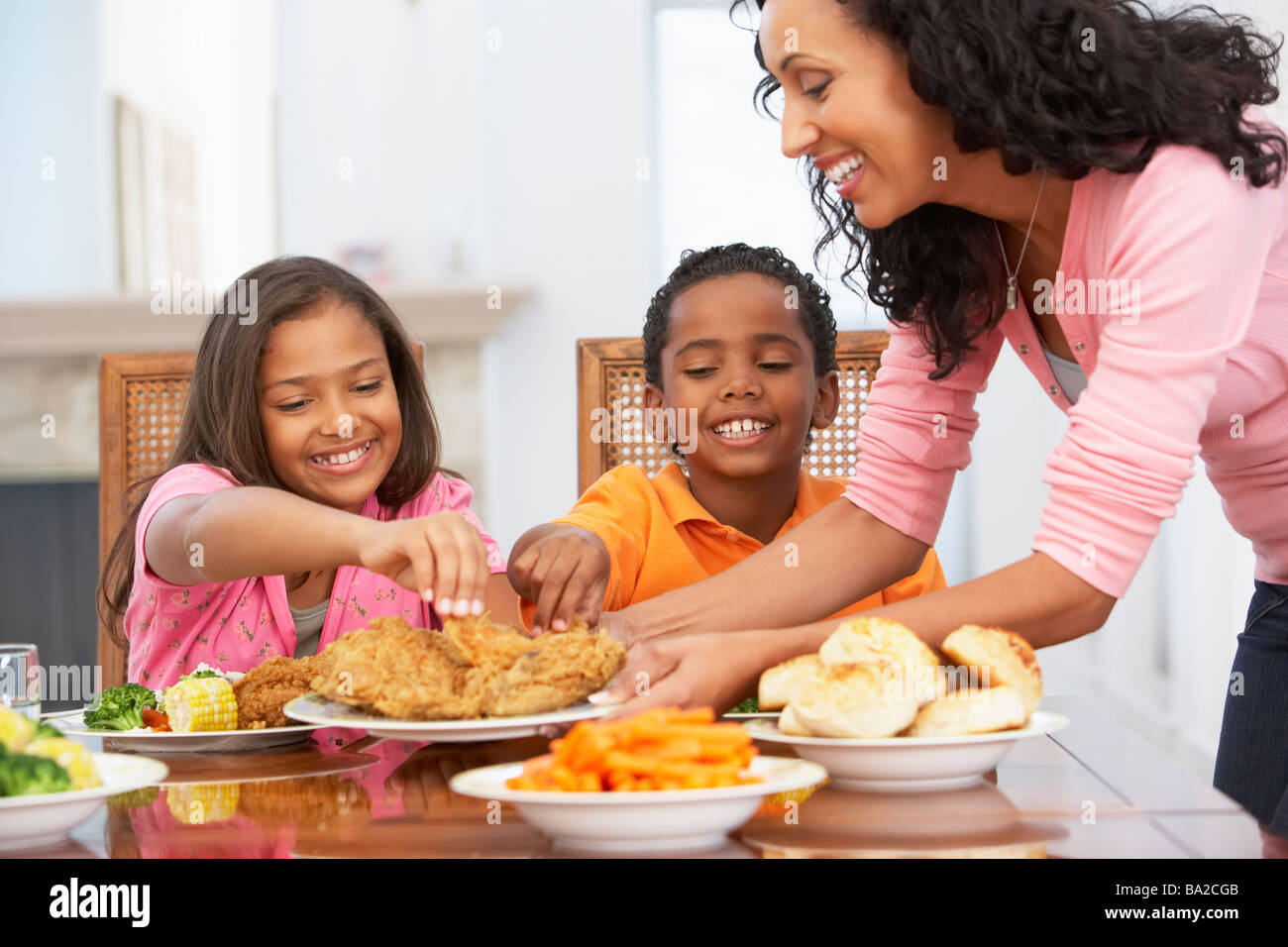 Madre di servire un pasto per i suoi figli a casa Foto Stock