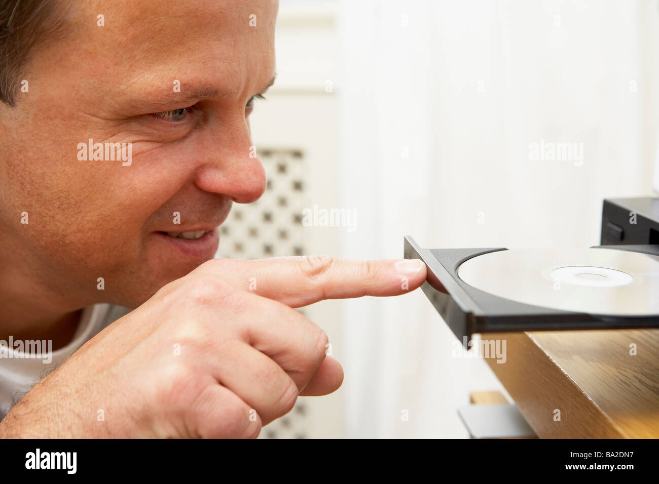 L'uomo chiudendo il lettore DVD con il dito Foto Stock