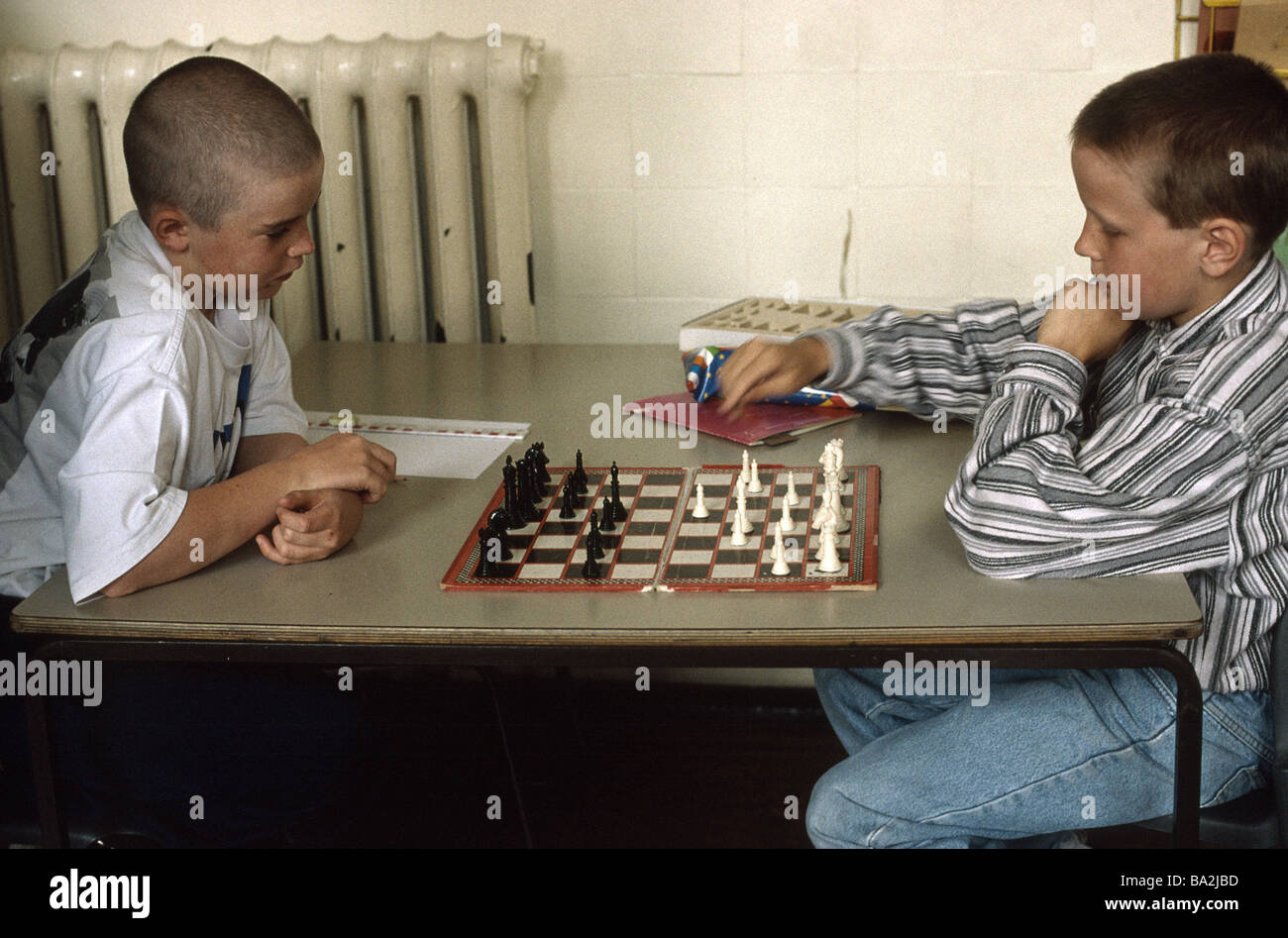 Due scuola primaria ragazzi giocare a scacchi Foto Stock