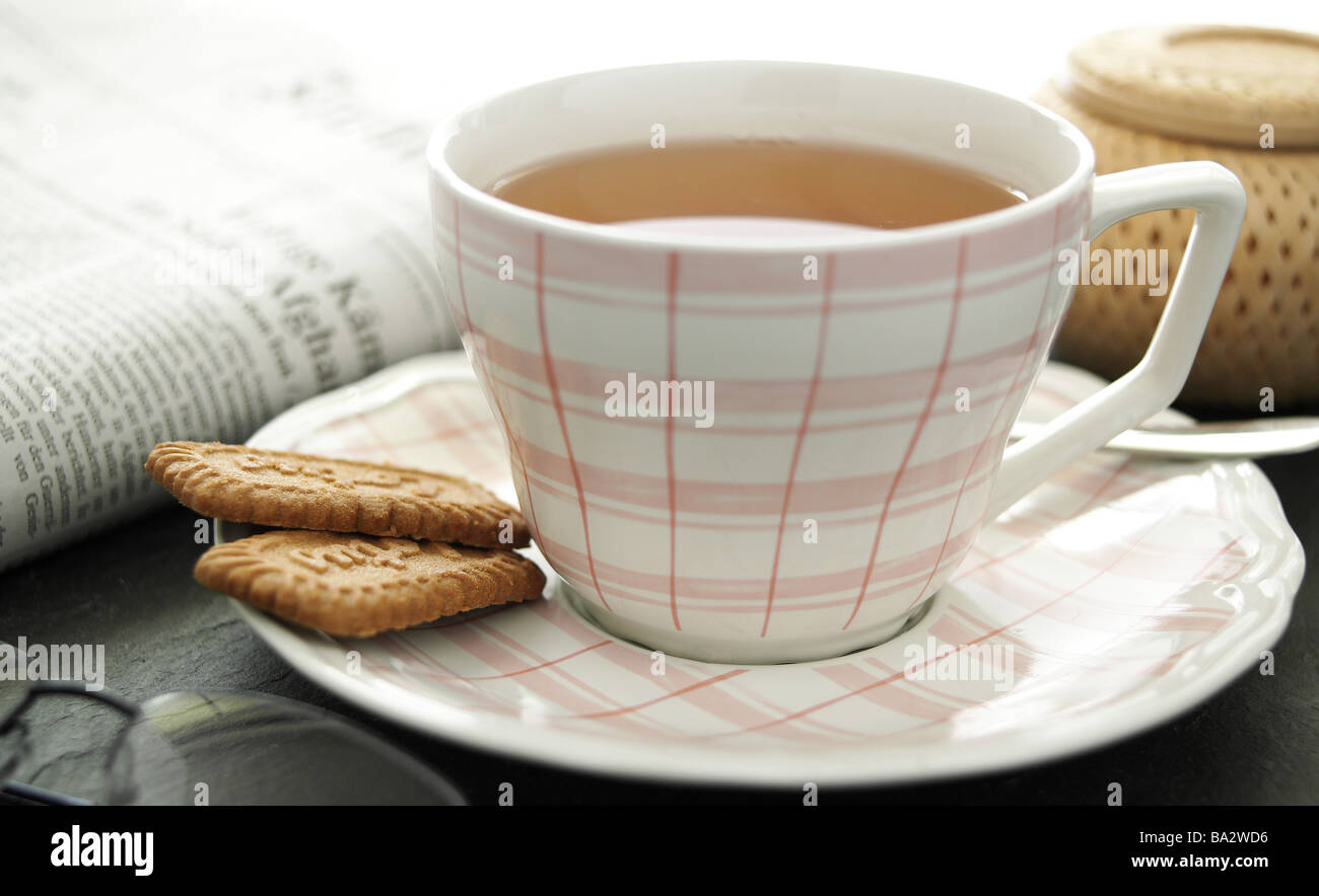 Tazzina pasticceria quotidiano di lettura occhiali Teatime Stilllife simbolo bevanda Teetrinken tazza da tè piattino luoghi i cookie Foto Stock