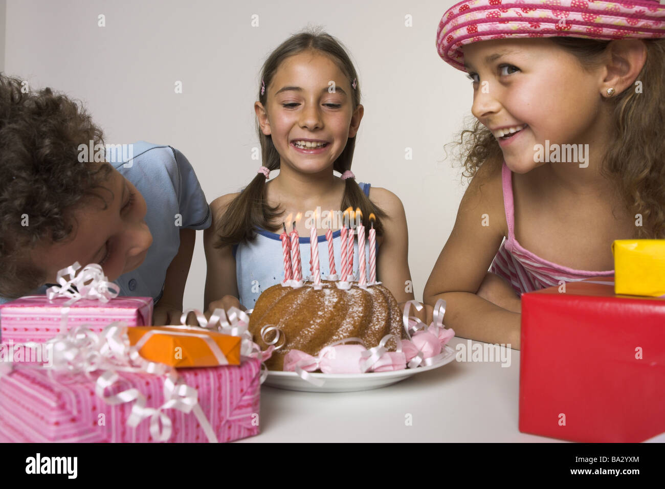 Le ragazze di compleanno torte candele si brucia gli ospiti orologi ritratto brocciato persone serie bambino-ritratto bambini ragazzo di tre amici Foto Stock