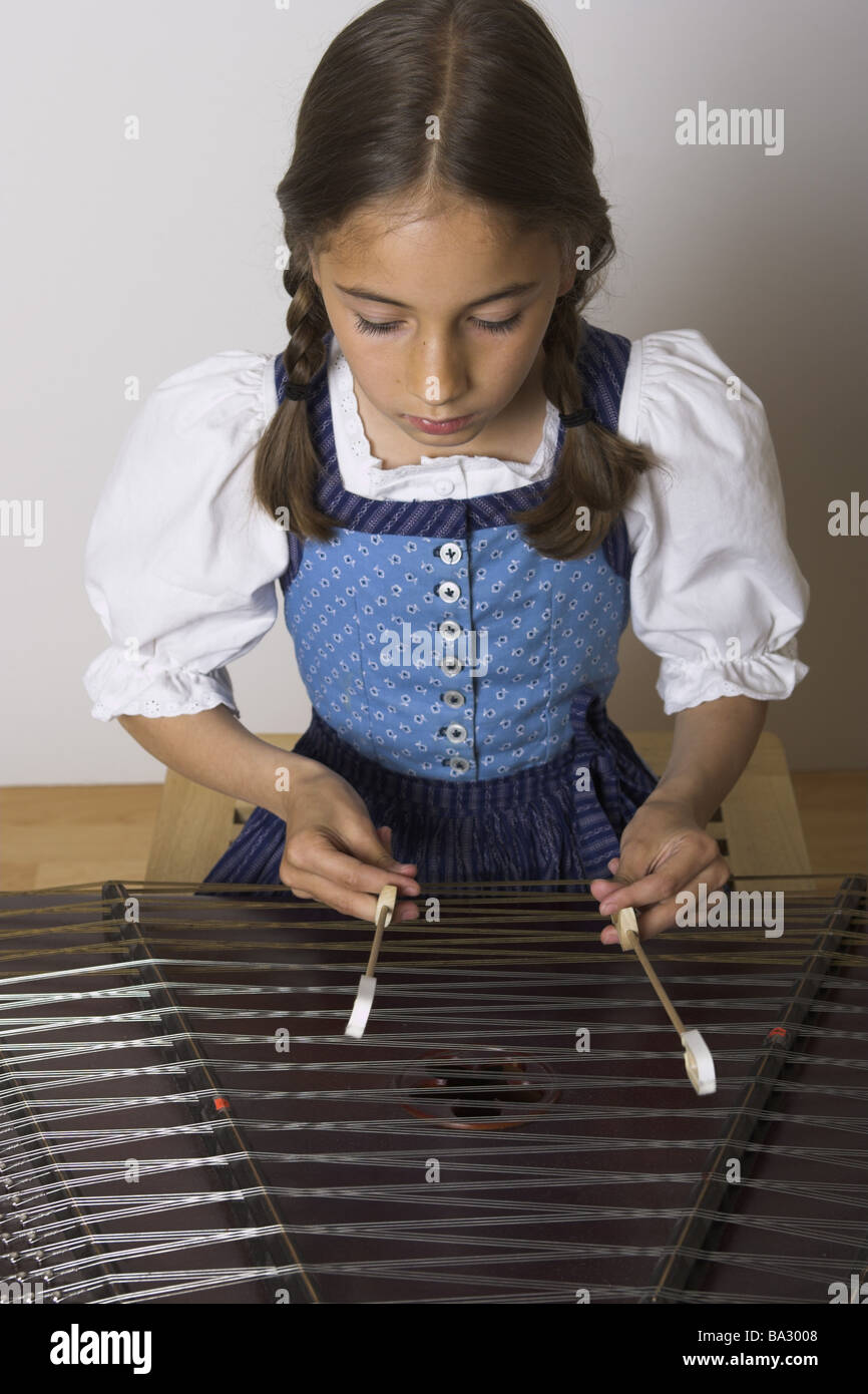 Ragazze tagliere semi-ritratto serie play persone bambino-ritratto bambino 8-10 anni bruna con i capelli lunghi trecce ben vestito con grembiule Foto Stock