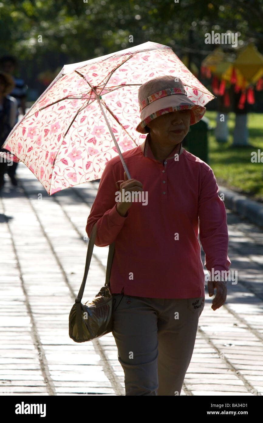 Donna vietnamita a piedi con un ombrello presso la cittadella imperiale di Hue Vietnam Foto Stock
