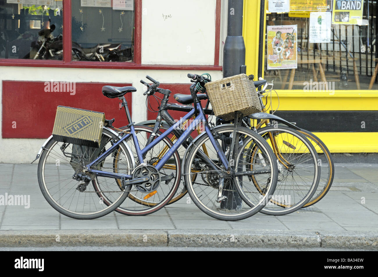 Biciclette con ceste incatenati a lampione Stoke Newington Church Street Hackney Londra Inghilterra REGNO UNITO Foto Stock