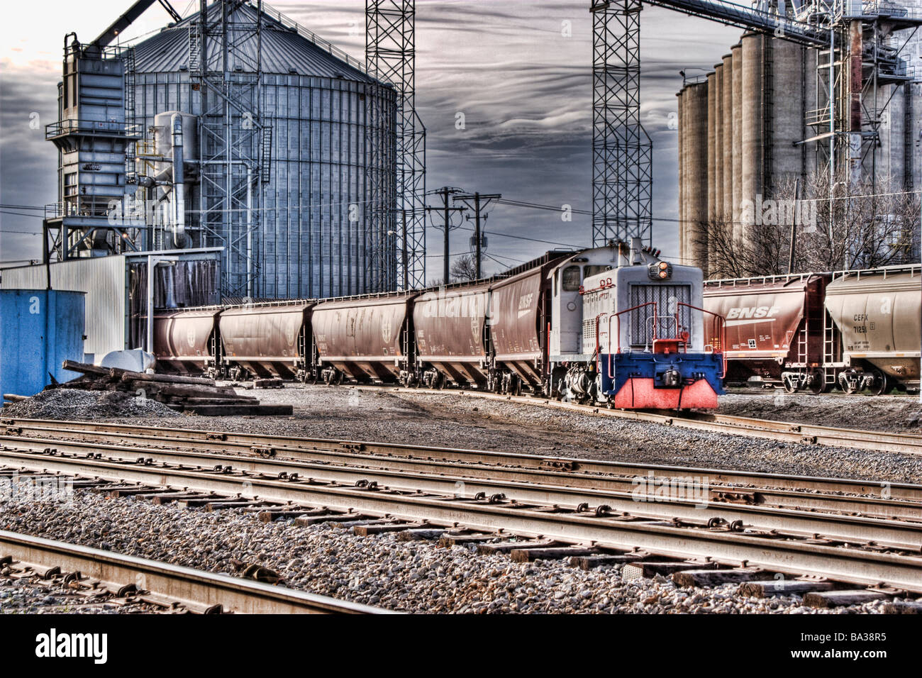 Immagine hdr di una locomotiva del treno tirando le vetture al di fuori di un mulino Foto Stock