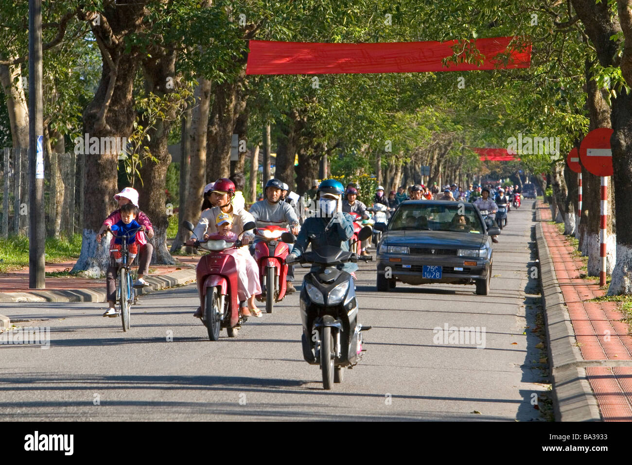 La gente ride moto lungo la cittadella imperiale di Hue Vietnam Foto Stock