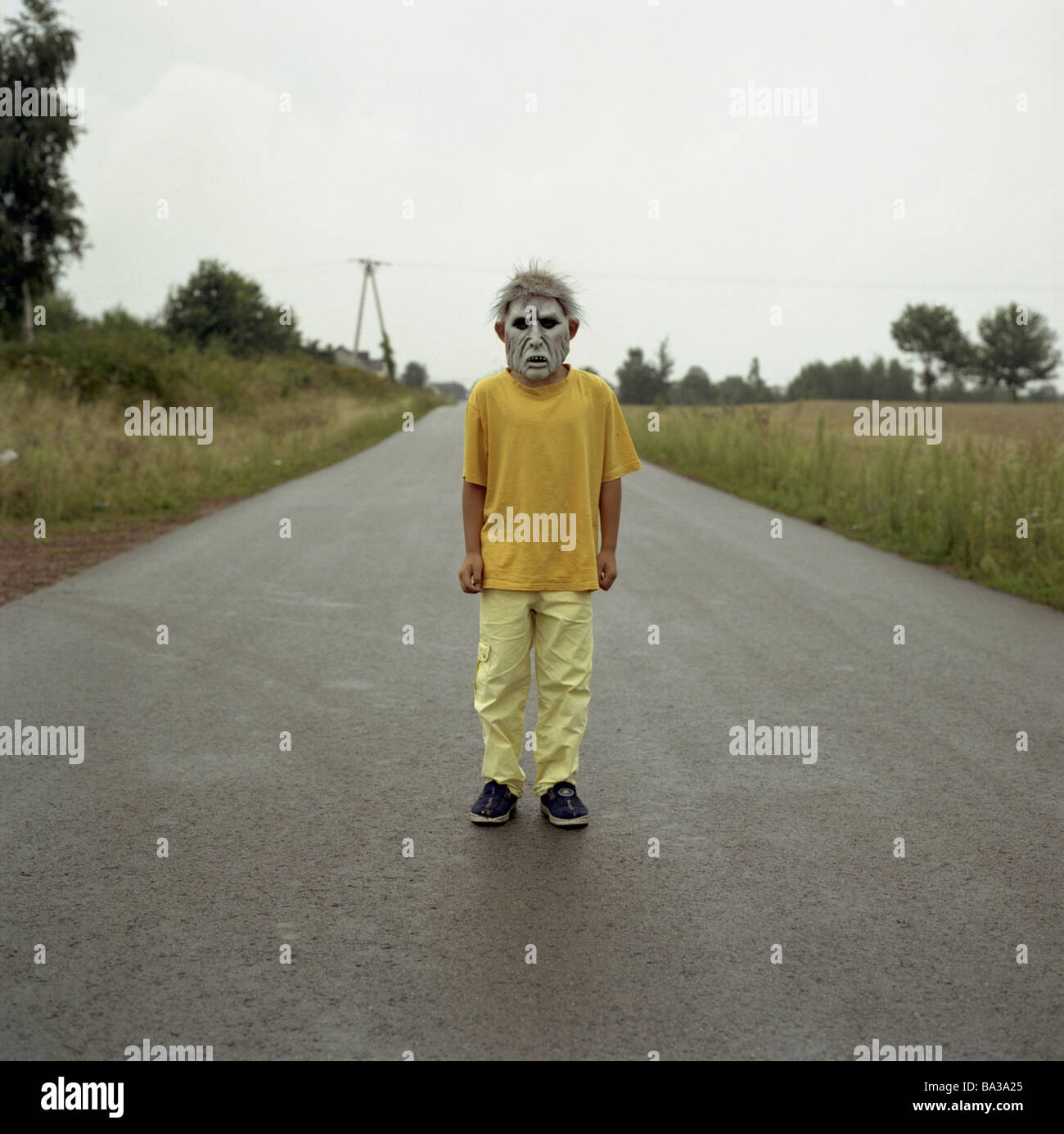 Country Road boy orrore-mask persone bambino T-shirt giallo maschera travestimento Fasching-maschera concetto fa sobbalzare crudelmente brutto orribile Foto Stock