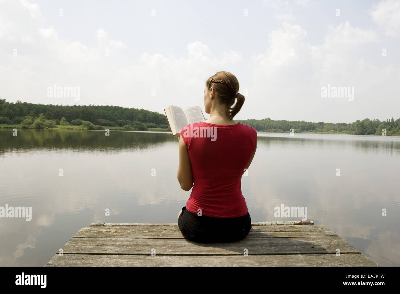 Donna giovane libro legge ponte siede back-parere persone serie abbastanza-corpi 24 anni 20-30 anni brunette coda di cavallo per il tempo libero Foto Stock