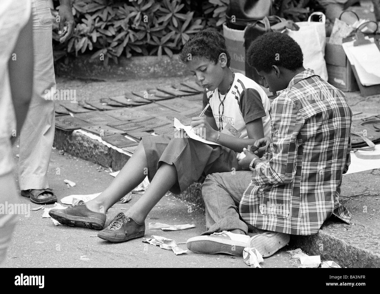 Negli anni settanta, foto in bianco e nero, persone, due ragazzi seduti al ciglio della strada, per il tempo libero, teeshirt, magliette, pantaloni, gomme, mulattos, di età compresa tra 14 a 18 anni, Brasile, Minas Gerais, Belo Horizonte Foto Stock