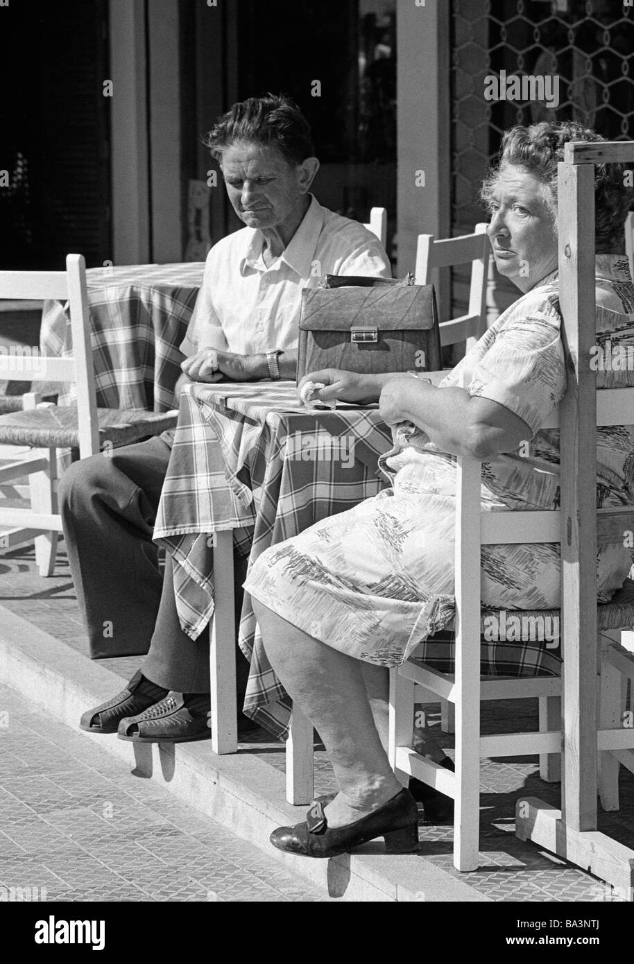 Negli anni settanta, foto in bianco e nero, persone anziana coppia siede su sedie in un marciapiede ristorante, abitanti locali, di età compresa tra i 70-80 anni, Isole Baleari Spagna, Maiorca Foto Stock