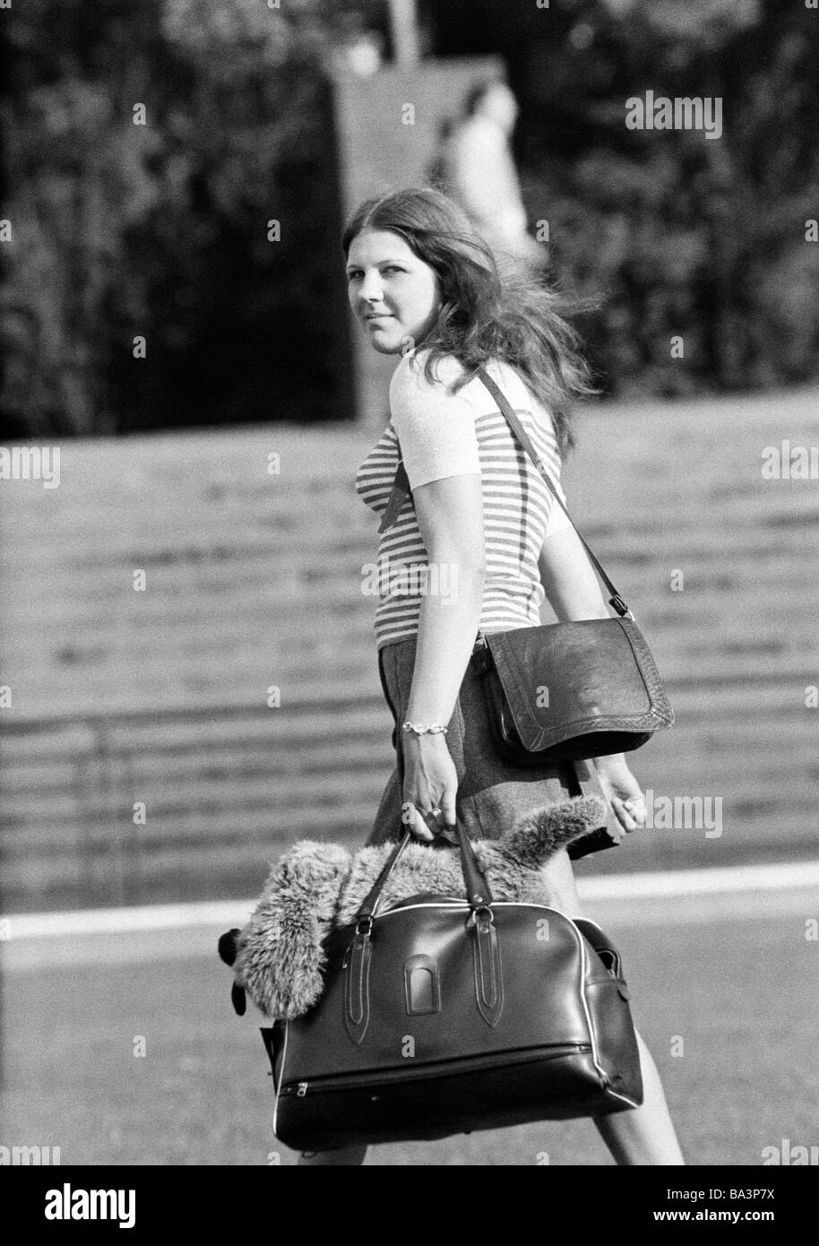 Negli anni settanta, foto in bianco e nero, persone, ragazza giovane con una borsetta e un sacchetto della spesa guardare indietro con la telecamera e di età compresa tra i 18 e i 22 anni Foto Stock
