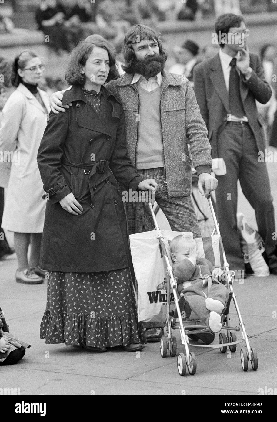 Negli anni settanta, foto in bianco e nero, persone, famiglia, genitori e un bambino nel passeggino stand su di una piazza e guardare un evento, l'uomo, di età compresa tra i 30-40 anni, donna di età compresa tra i 30-40 anni, ragazzo, di età compresa tra 1 anno, Gran Bretagna, Inghilterra, Londra Foto Stock