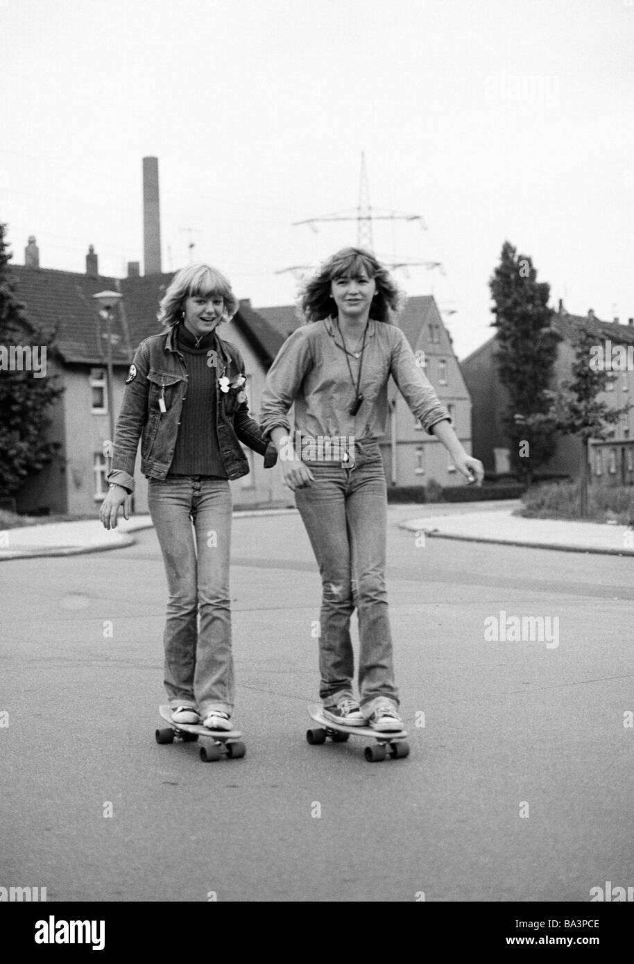 Negli anni settanta, foto in bianco e nero, persone, due giovani ragazze con i pattini guidare su strada, jeans tuta, jeans pantaloni, di età compresa tra 15 a 18 anni Foto Stock