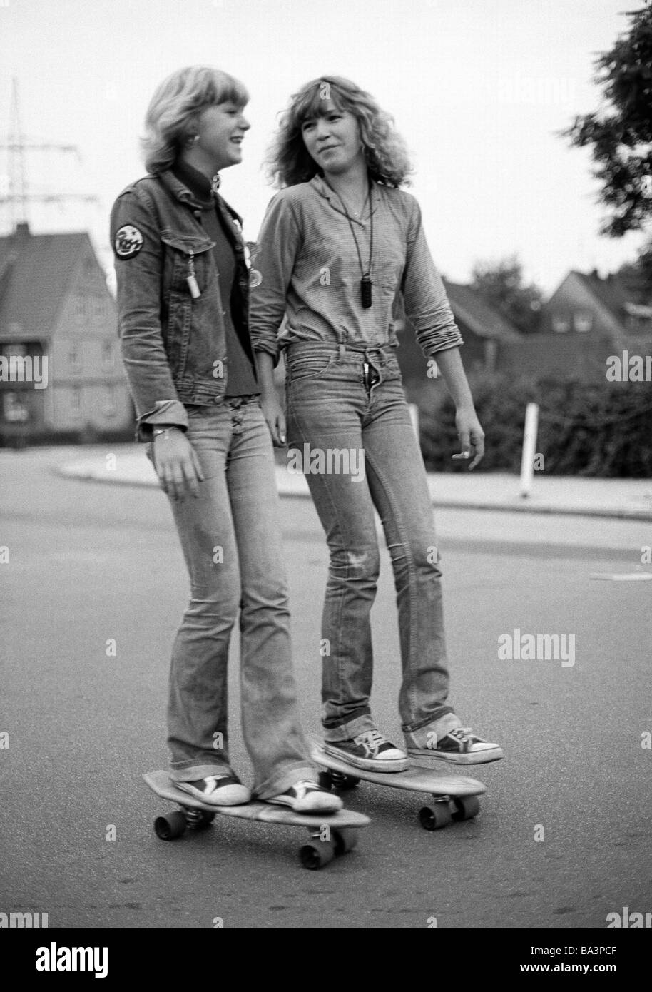 Negli anni settanta, foto in bianco e nero, persone, due giovani ragazze con i pattini guidare su strada, jeans tuta, jeans pantaloni, di età compresa tra 15 a 18 anni Foto Stock