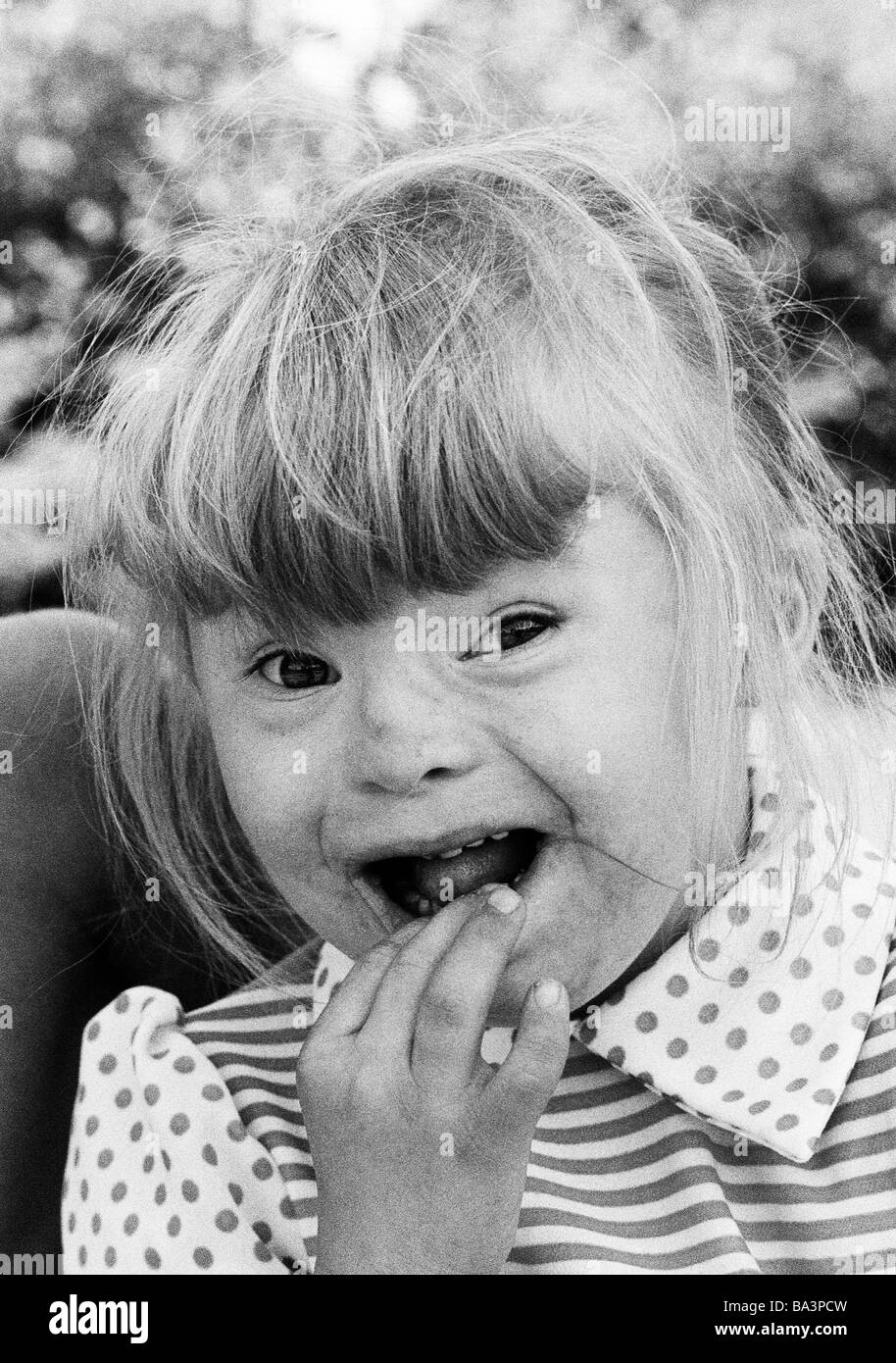 Negli anni settanta, foto in bianco e nero, persone di handicap fisici, ragazza con la sindrome di Down, ansioso, ampia bocca aperta, ritratto, dai 6 ai 10 anni Foto Stock