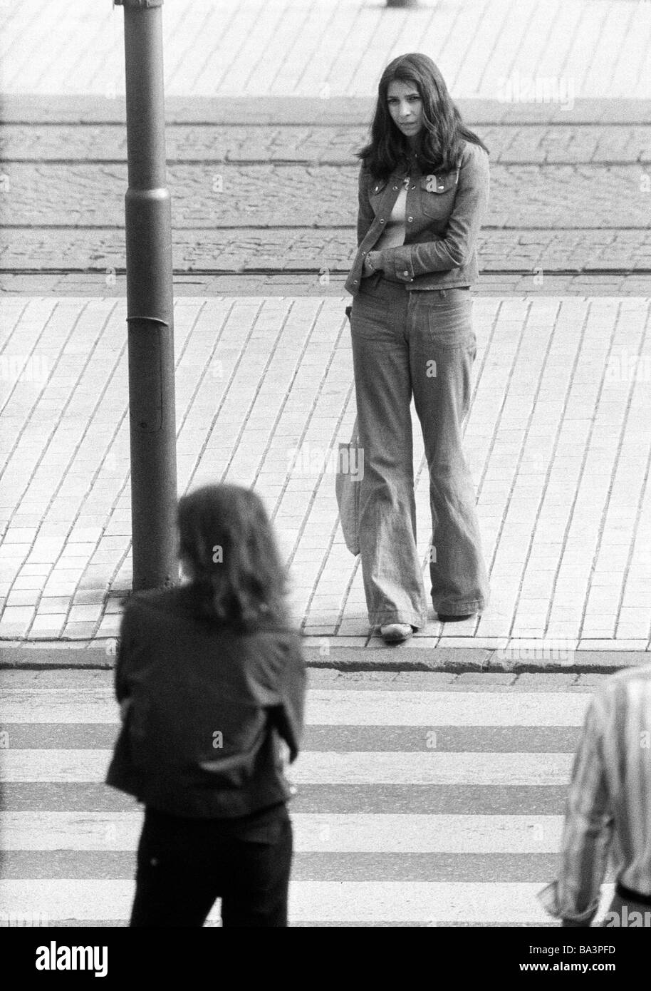 Negli anni settanta, foto in bianco e nero, persone giovane ragazza sulla strada, jeans tuta, in attesa di una zebra crossing, di età compresa tra i 18 e i 22 anni Foto Stock