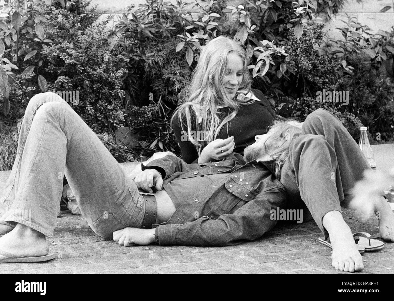 Negli anni settanta, foto in bianco e nero, la gente giovane coppia giace sul terreno, teneramente, di età compresa tra i 18 e i 25 anni, Paesi Bassi, Amsterdam Foto Stock