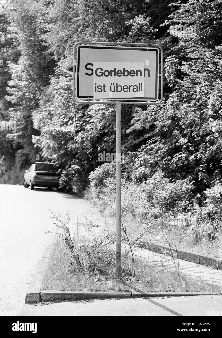 Ottanta, foto in bianco e nero, ecologia, energia nucleare, il nome della città in un luogo-nome sign è incollato su dallo slogan "Gorleben è ovunque", un allusione al nucleare per lo smaltimento dei rifiuti nel sito di Gorleben, D-Gorleben, Samtgemeinde Gartow, Elba, riserva della biosfera inferiore Elbtalaue sassone, Bassa Sassonia Foto Stock