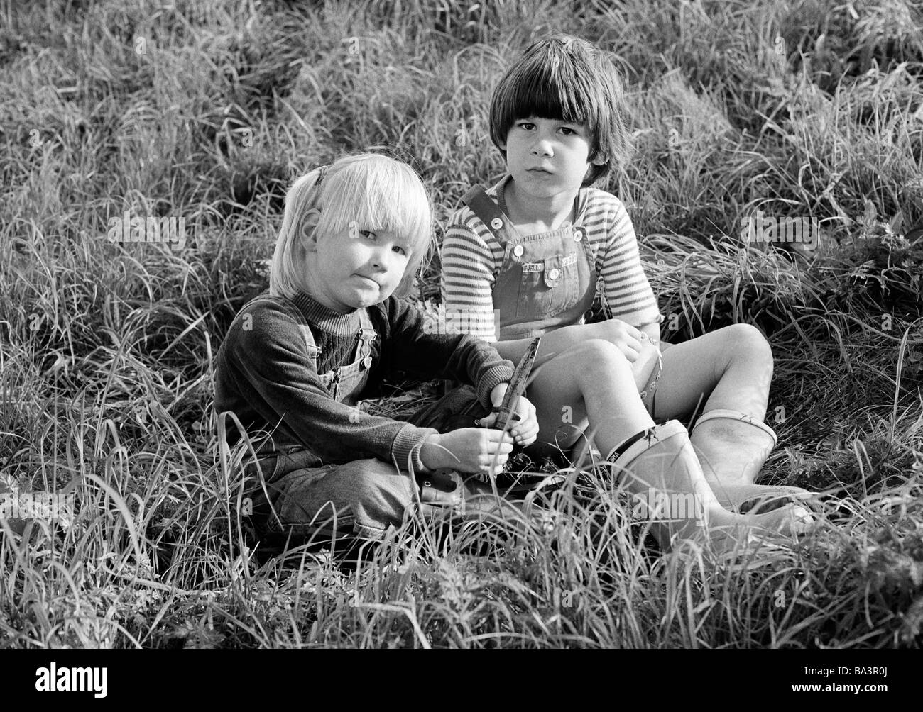 Ottanta, foto in bianco e nero, persone, bambini, due bambine sit in erba, prato, di età compresa tra i 4 ed i 8 anni Foto Stock