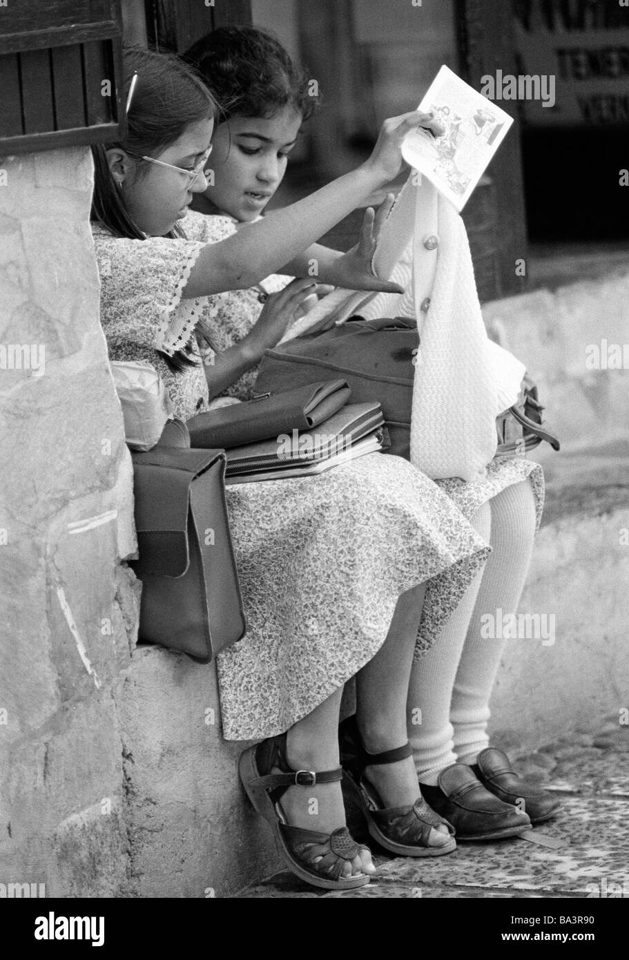 Ottanta, foto in bianco e nero, persone, bambini, due studentesse di sedersi su un muro con la loro schoolbags, di età compresa tra 9 e 12 anni, Spagna, Canarie, Canarie, Tenerife, Puerto de la Cruz Foto Stock