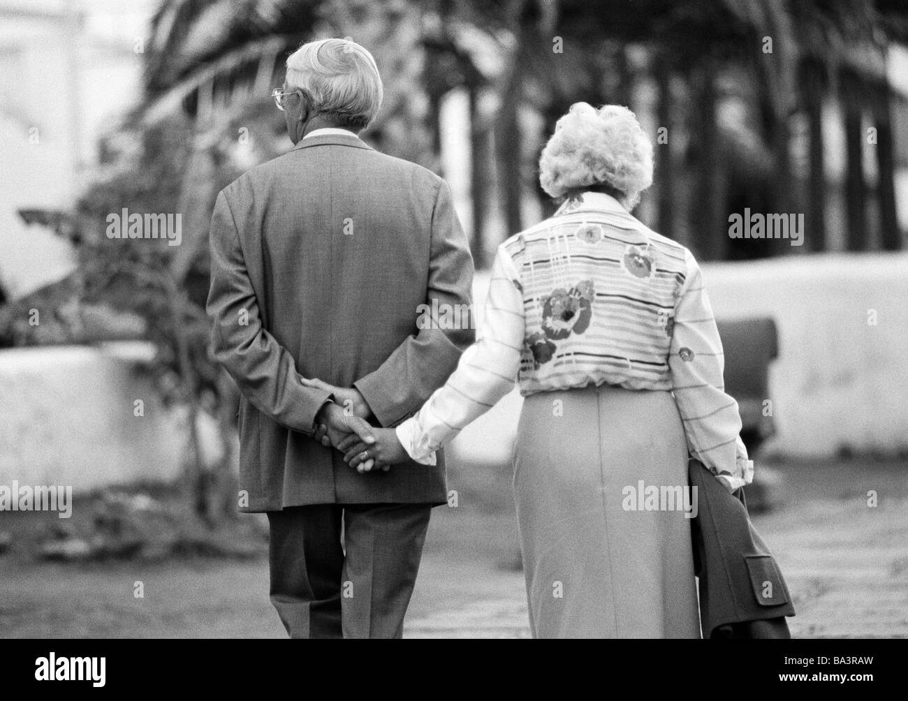 Ottanta, foto in bianco e nero, persone, anziani, coppia di anziani camminare mano nella mano, tenendo le mani, tuta, camicetta, gonna, di età compresa tra i 65 e gli 75 anni, Spagna, Canarie, Canarie, Puerto de la Cruz Foto Stock