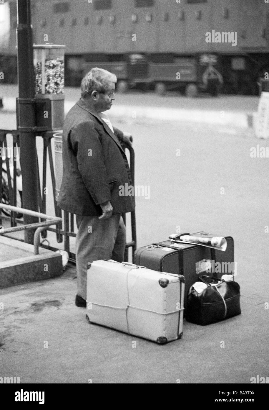 Negli anni settanta, foto in bianco e nero, persone, uomo vecchio sorge su una piattaforma, stazione ferroviaria, valigie, bagagli, di età compresa tra 60 a 70 anni, l'Italia, Lombardia, Milano Foto Stock