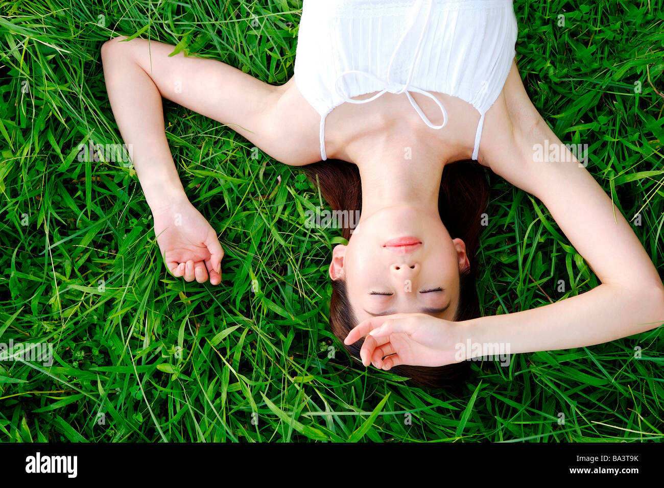 Ritratto di giovane donna sdraiata su erba Foto Stock