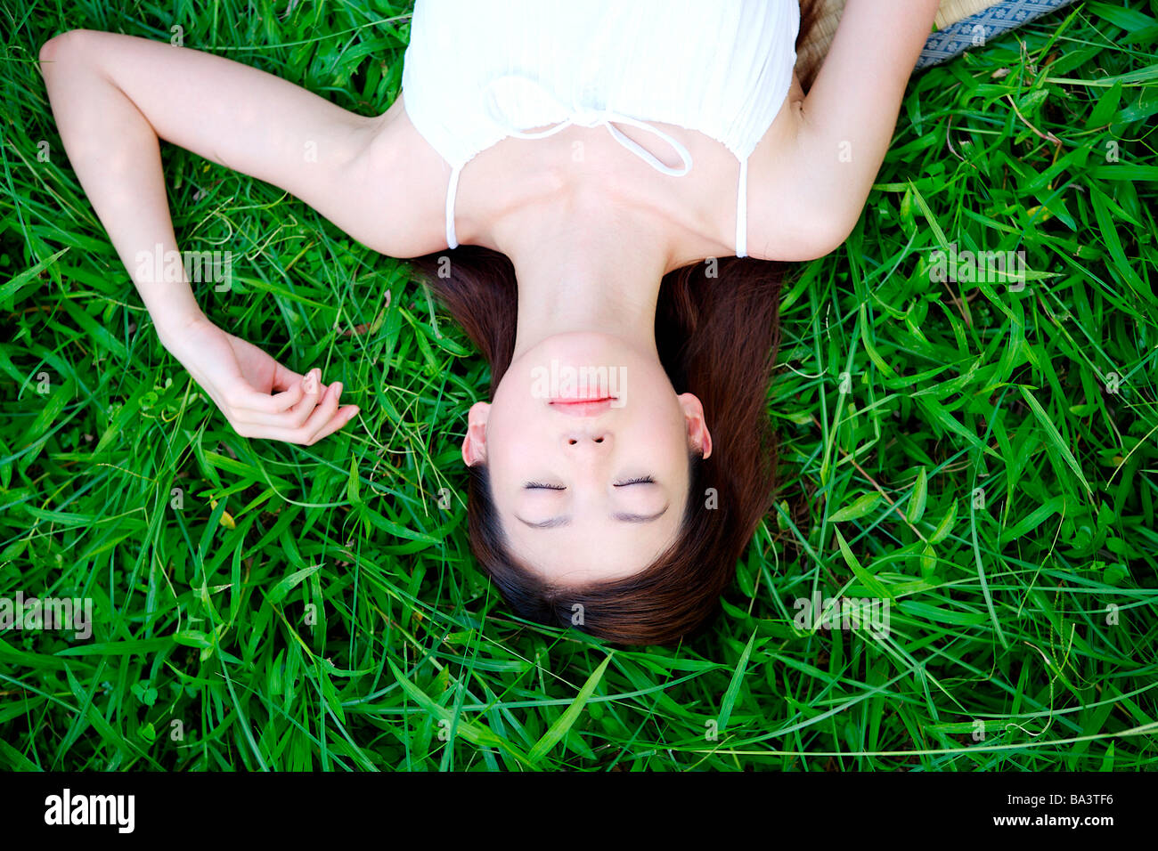 Ritratto di giovane donna sdraiata su erba Foto Stock