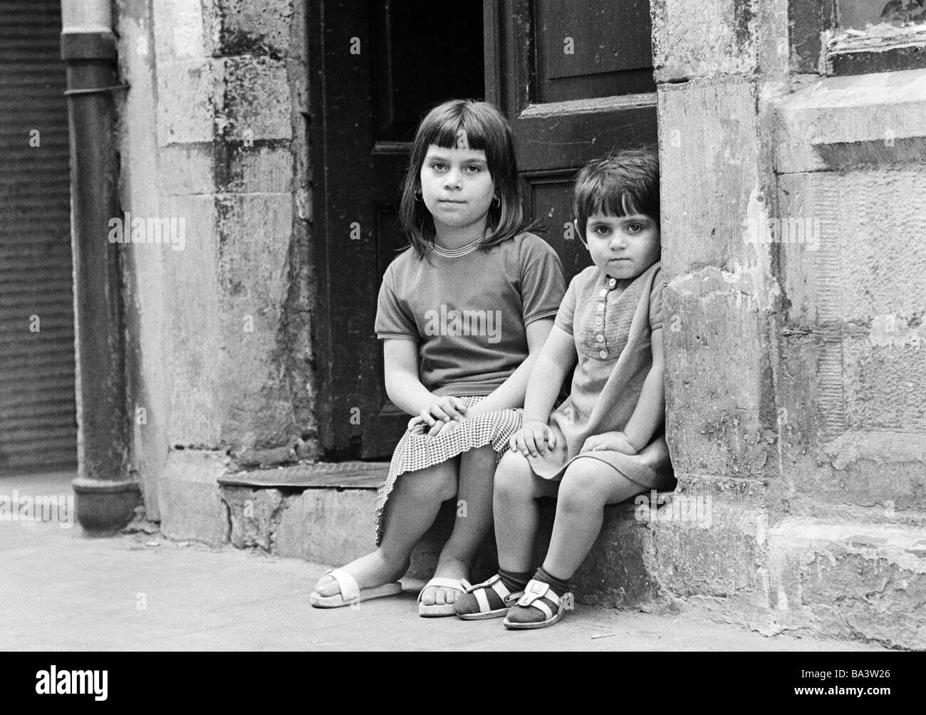 Anni sessanta, foto in bianco e nero, persone, bambini, due bambine seduto  davanti a un housedoor,