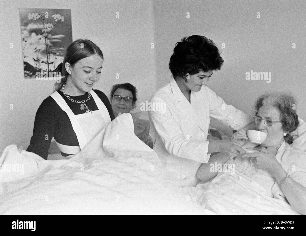 Negli anni settanta, foto in bianco e nero, persone, salute, un infermiere e un studente di infermieristica in ospedale a cura di due donne anziane, di età compresa tra i 18 e i 25 anni di età compresa tra i 25 e i 30 anni di età compresa tra 65 a 75 anni Foto Stock