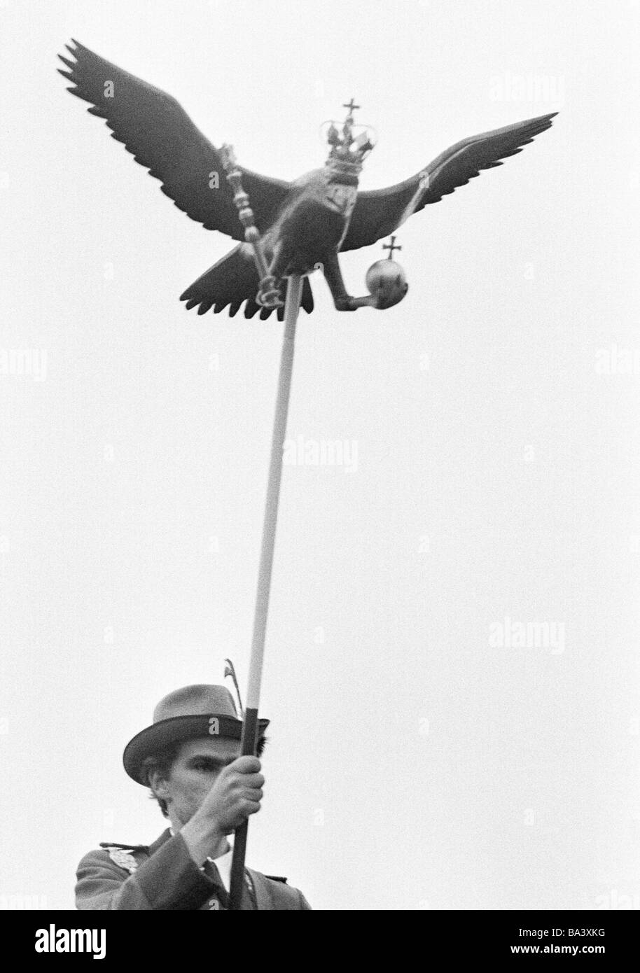 Negli anni settanta, foto in bianco e nero, persone, gara di tiro, pistolero porta un Popinjay su un asta per le riprese di uccelli Foto Stock Negli anni settanta, foto in bianco e nero, persone, gara di tiro, pistolero porta un Popinjay su un asta per le riprese di uccelli Foto Stock
