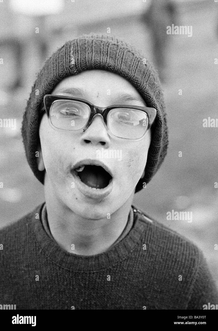 Negli anni settanta, foto in bianco e nero, persone di handicap fisici, Ragazzo con occhiali e wooly hat, aperto bocca, ritratto, di età compresa tra i 10 e i 14 anni Foto Stock