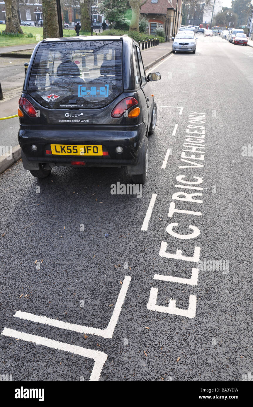 Auto elettrica essendo caricato con un cavo collegato alla presa di corrente Foto Stock