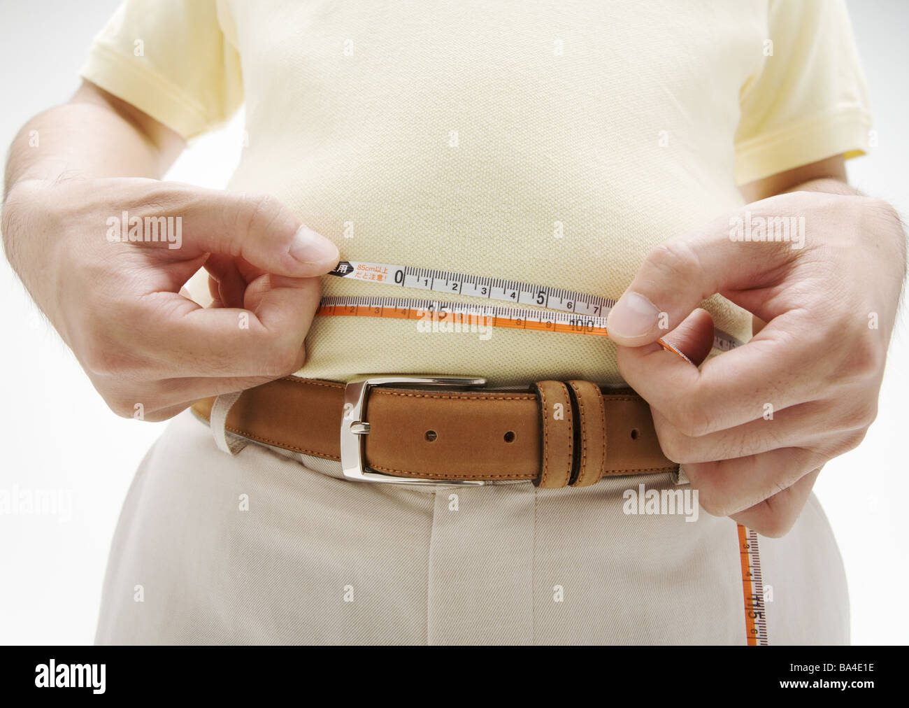 Un uomo misurando la sua vita Foto Stock