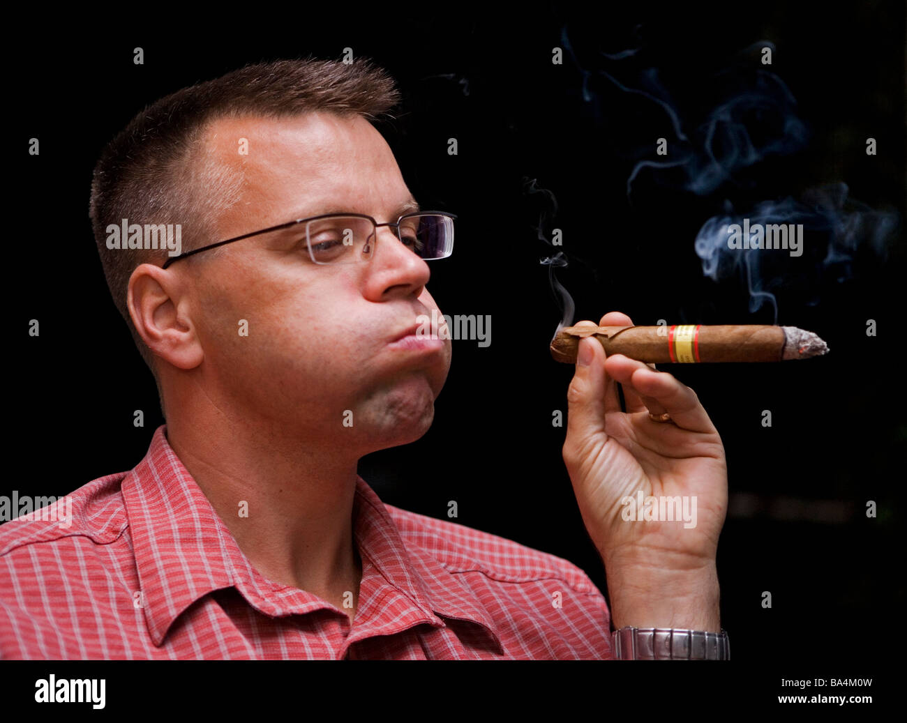 Uomo di fumare il sigaro. Foto Stock