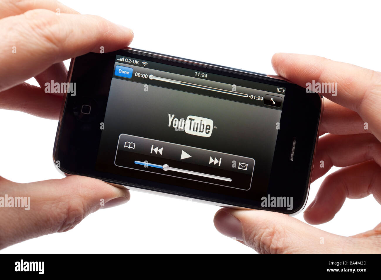 Maschio di mani tenendo lo smartphone iPhone smart phone telefono cellulare la visione di un video clip che mostra il caricamento del logo di YouTube Foto Stock