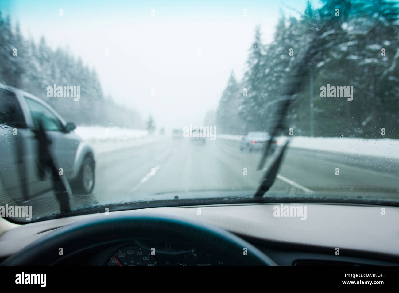 La guida nel paraurti paraurti per il traffico attraverso le montagne in una pioggia tempesta di neve Foto Stock